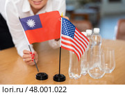 Office coordinator setting flags of Taiwan and United States on table. Стоковое фото, фотограф Яков Филимонов / Фотобанк Лори