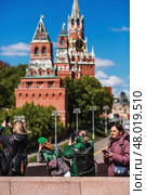 Russia, Moscow, April 28, 2025. Foreigners in Russia. Tourists are photographed against the backdrop of the Kremlin and famous sights of Moscow. Tourism and travel. Редакционное фото, фотограф Photojuli / Фотобанк Лори