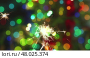 Sparkler burning on multicolor background. Стоковое видео, видеограф Михаил Коханчиков / Фотобанк Лори