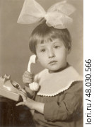 Девочка с большим бантом и телефонной трубкой, 1970-е гг, СССР. Редакционное фото, фотограф Retro / Фотобанк Лори