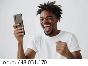 Молодой человек радуется сообщению. Стоковое AI-изображение, AI-художник Александр Жуков / Фотобанк Лори