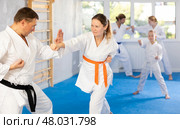 Woman is paired with man teacher to learn how to strike and rehearses blocking opponent. Стоковое фото, фотограф Яков Филимонов / Фотобанк Лори