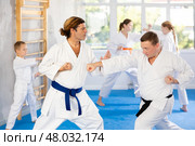 Man father is paired with coach to learn how to strike and rehearses blocking opponent. Стоковое фото, фотограф Яков Филимонов / Фотобанк Лори