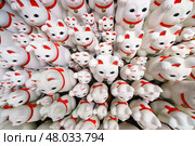 Tokyo, Japan - Sep 30 2024, A close-up view of many multi-sized white beckoning cat figure of Maneki neko with red ears and noses displayed at Gotokuji Temple, without people, at daytime, Tokyo, Japan. Стоковое фото, фотограф Сергей Богомяко / Фотобанк Лори