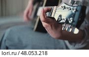 Woman Practicing Guitar in Cozy Room at Home. Strumming black acoustic guitar. Female learning to play music. Person hand on a guitar neck. Guitarist working on melody, performance, practice indoors. Стоковое видео, видеограф Марина Демидюк / Фотобанк Лори
