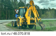 Экскаватор-погрузчик JCB на обочине дороги. Редакционное фото, фотограф Антон Моргунов / Фотобанк Лори