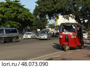 Красный тук-тук на оживленной городской дороге в дневное время. Red Tuk-Tuk on Busy Urban Road during Daytime Traffic (2018 год). Редакционное фото, фотограф Соболева Наталия / Фотобанк Лори