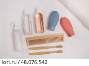A travel set of toiletries is neatly laid out on a white surface. It includes essential personal hygiene items in bottles. Стоковое фото, фотограф Виктория Тельминова / Фотобанк Лори
