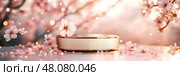 A luxurious gold-leafed podium captures attention beneath a pastel pink sky. Cherry blossom petals grace the scene, creating an elegant and serene atmosphere in soft, golden light. Стоковое AI-изображение, AI-художник Nart / Фотобанк Лори