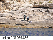 Дайверы на скалистом берегу Атлеша на мысе Тарханкут в Крыму (2014 год). Редакционное фото, фотограф Мария Деркунская / Фотобанк Лори