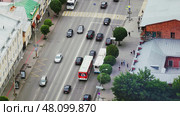 A busy urban street bustling with various buses, cars, and vibrant city life all around. Стоковое фото, фотограф David Kashakhi / Фотобанк Лори