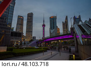 Shanghai, China - 1 April 2025: Evening view of Oriental Pearl Tower and Pudong skyscrapers in Shanghai. Bridge lights and city glow create vibrant urban scene. Редакционное фото, фотограф Татьяна Терехина / Фотобанк Лори