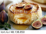 Creamy brie cheese topped with fresh figs and honey on a marble surface. Сливочный сыр бри со свежим инжиром и медом на мраморной поверхности. Стоковое AI-изображение, AI-художник Katsiaryna Repich / Фотобанк Лори