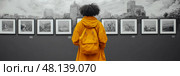 A person in a yellow coat stands captivated in front of black and white artwork in a gallery, surrounded by historical urban visuals. Стоковое AI-изображение, AI-художник Данила Большаков / Фотобанк Лори