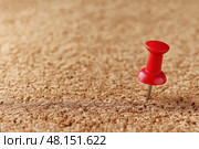 Single Red Pushpin on Empty Cork Board as a Symbol of Waiting or Anticipation. Красная булавка, воткнутая в пустую пробковую доску, изолированная и одинокая, метафора ожидания или надежды. Стоковое AI-изображение, AI-художник Katsiaryna Repich / Фотобанк Лори
