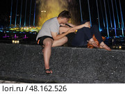 Влюблённые молодые люди у фонтана ночью (2015 год). Редакционное фото, фотограф Сергей Костин / Фотобанк Лори