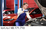 Female auto mechanic checking oil level in car engine in garage. Стоковое видео, видеограф Яков Филимонов / Фотобанк Лори