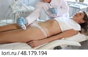 Cosmetologist using cold hammer for hardware procedure on anterior thighs of female client in cosmetology office. Non-surgical body sculpting concept. Стоковое видео, видеограф Яков Филимонов / Фотобанк Лори