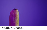 In the process of learning the basics of sex life, a banana is watered with a lubricant and then a woman puts a condom on it. Стоковое видео, видеограф Strunov David / Фотобанк Лори