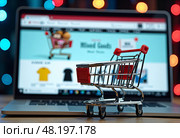 Клавиатура ноутбука с маленькой тележкой из супермаркета. Покупка продуктовых и промышленных товаров в интернет магазинах онлайн. A laptop keyboard with a small supermarket cart. Purchase of grocery and industrial goods in online stores online. Стоковое AI-изображение, AI-художник Гер Олег / Фотобанк Лори