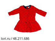 Vibrant red dress features playful black polka dots and a flared skirt, ideal for little girls during warm weather events. Стоковое фото, фотограф Данила Большаков / Фотобанк Лори