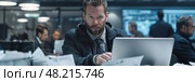 Analysts collaborate in a busy office, meticulously examining critical reports and data under tight time constraints. Стоковое AI-изображение, AI-художник Данила Большаков / Фотобанк Лори