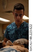 Medical Student Practicing Suturing Techniques on a Mannequin in a Classroom Setting. Стоковое AI-изображение, AI-художник Данила Большаков / Фотобанк Лори