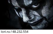 An individual with striking dark makeup displays an intriguing expression, embodying the atmosphere of a night filled with mystery at an event. Стоковое AI-изображение, AI-художник Данила Большаков / Фотобанк Лори