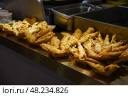 Golden battered fish fillets displayed in paper trays at a Chinese street food stall. Hot, crunchy and freshly deep-fried in oil. Стоковое фото, фотограф Татьяна Терехина / Фотобанк Лори