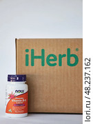 Jar of vitamin D3 NOW Foods Company, near iHerb Brown Cardboard box. Редакционное фото, фотограф Екатерина Якименко / Фотобанк Лори