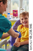 A nurse is giving a young boy a vaccination in a clinic setting. Стоковое AI-изображение, AI-художник Данила Большаков / Фотобанк Лори