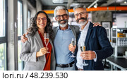 Three Colleagues Joyously Toast Their Success With a Celebratory Bottle of Champagne in Their Office Setting, Embracing Their Hard-Earned Accomplishments. Стоковое AI-изображение, AI-художник Данила Большаков / Фотобанк Лори