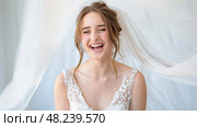 The Blushing Bride Radiates Happiness as She Smiles Under Her Delicate Veil on Her Special Wedding Day. Стоковое AI-изображение, AI-художник Данила Большаков / Фотобанк Лори