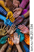 A group of people with painted hands joined together in unity during the Holi festival. Стоковое AI-изображение, AI-художник Данила Большаков / Фотобанк Лори