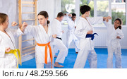 Teen girl karateka honing punches during kumite in training room. Стоковое фото, фотограф Яков Филимонов / Фотобанк Лори