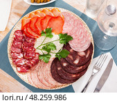 Slices of Spanish dry-cured gammon, variety of sausages. Стоковое фото, фотограф Яков Филимонов / Фотобанк Лори