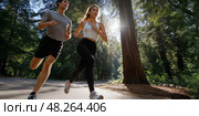 Wide angle shot of a couple running in the park. Intentional motion blur on the man. Energetic posture. Стоковое AI-изображение, AI-художник Катерина Ковалева / Фотобанк Лори
