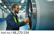 A close-up of a worker inspecting a jet engine in an aerospace facility, the intricate machinery illuminated by cool white lights. Стоковое AI-видео, аниматор Sergey Grishin / Фотобанк Лори