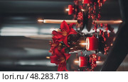 A melancholic indoor setting with a black table adorned with red lilies and candles, casting soft shadows to enhance the mood of sorrow and reflection. Стоковое AI-видео, аниматор Ирина Старикова / Фотобанк Лори