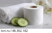 Toilet Paper Roll in Spa Setup, Cucumber Slices and Towel Wrap for Relaxation. Рулон туалетной бумаги в спа-салоне, ломтики огурца и полотенце для релаксации. Стоковое AI-изображение, AI-художник Katsiaryna Repich / Фотобанк Лори