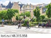 cyclists ride along the boulevard Saint Marcel past the Library Of The Institute Of Human Paleontology (2018 год). Редакционное фото, фотограф Ирина Мойсеева / Фотобанк Лори
