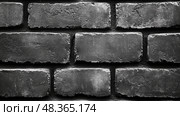 Textured black bricks are arranged closely together, showcasing their rough surfaces and irregularities in a monochrome backdrop. Стоковое AI-изображение, AI-художник Данила Большаков / Фотобанк Лори