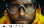 A determined individual stares directly ahead while wearing protective goggles and a bright yellow rain jacket in an outdoor setting. Стоковое AI-изображение, AI-художник Данила Большаков / Фотобанк Лори