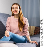 Portrait of a smiling young woman sitting on a sofa. Стоковое фото, фотограф Яков Филимонов / Фотобанк Лори