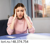 Portrait of a frustrated young woman sitting at a table. Стоковое фото, фотограф Яков Филимонов / Фотобанк Лори