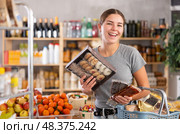 Young woman choosing sweets in grocery store. Стоковое фото, фотограф Яков Филимонов / Фотобанк Лори