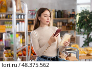 Girl scan QR-code on cheese in store. Стоковое фото, фотограф Яков Филимонов / Фотобанк Лори