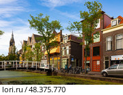 Delft, Netherlands - August 07, 2022: Street, brick buildings and bicycles on day in Delft. Calm and graceful village full of canals and Gothic architecture. Редакционное фото, фотограф Яков Филимонов / Фотобанк Лори