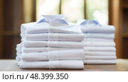 style white shirts stacked ai generated. Стоковое AI-изображение, AI-художник Vectorwin / Фотобанк Лори