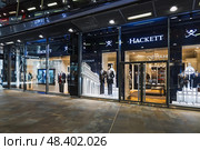 Premium Hackett menswear store exterior with illuminated signage. London, UK, 29 March 2024. Редакционное фото, фотограф Zydrius Tartenis / Фотобанк Лори